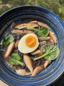 Blue bowel with black rice noodles, shitake mushrooms, greens and broth