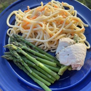 Blue plate with asparagus spears, chicken and bucatini pasta